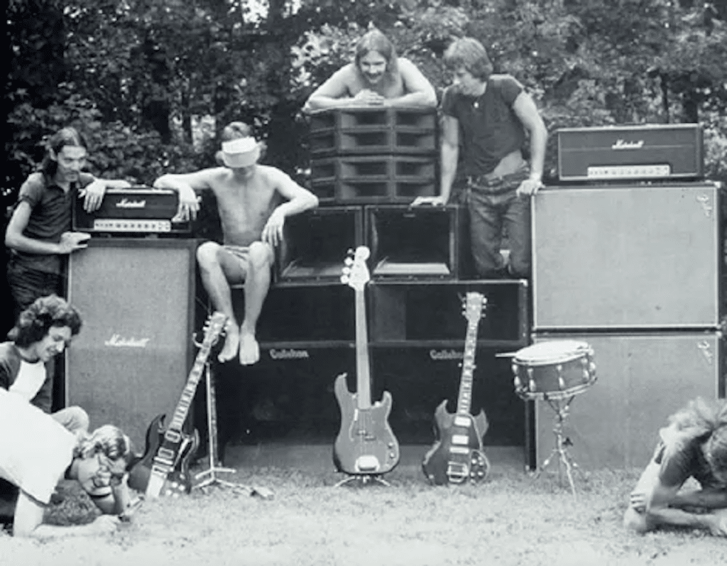 Vintage photo of George Brigman and band with guitars, amps, and drum equipment, 1970s underground rock setup.