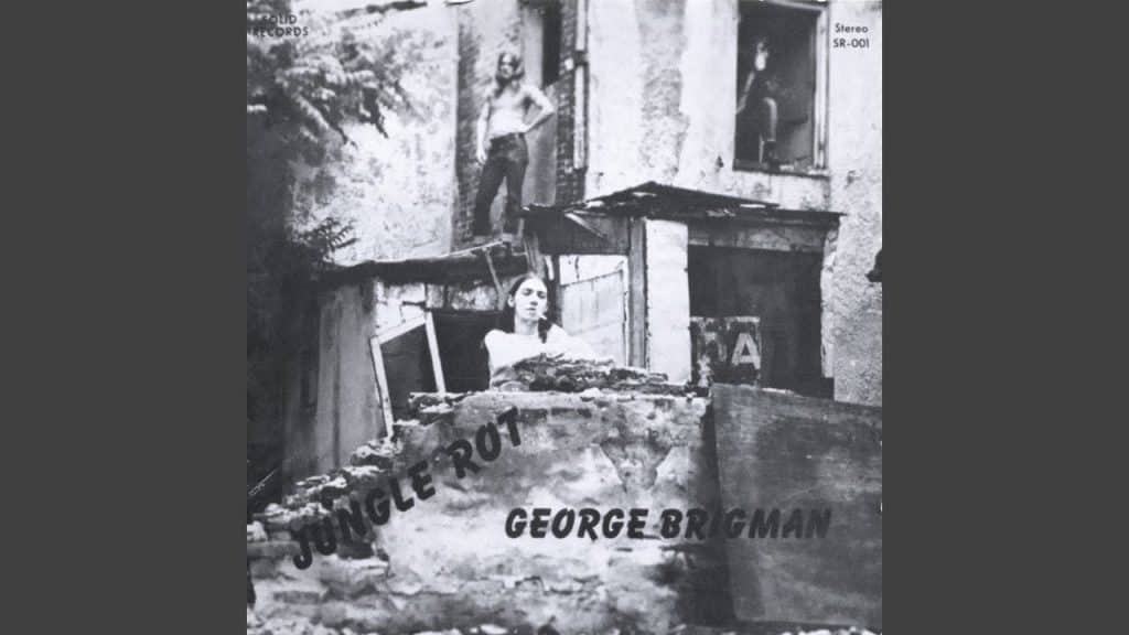 Cover of George Brigman’s 1975 album Jungle Rot, featuring a black-and-white photo of the artist among decayed buildings.